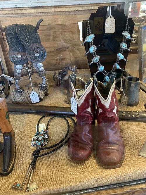 antique spurs, turquoise jewelery and cowboy boots on a display table